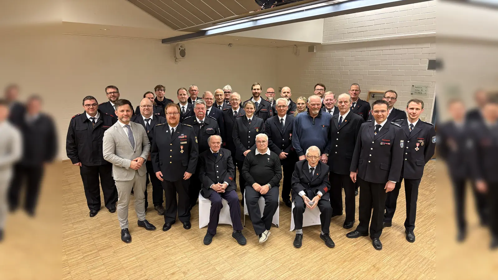Gruppenfoto aller geehrten Feuerwehrleute des Abends mit den frisch ernannten Jugendwarten aus Amelunxen, der Leitung der Feuerwehr, Bürgermeister Tino Wenkel und dem ebenfalls geehrten Kreisbrandmeister Stefan Nostitz (Foto: Barbara Siebrecht)