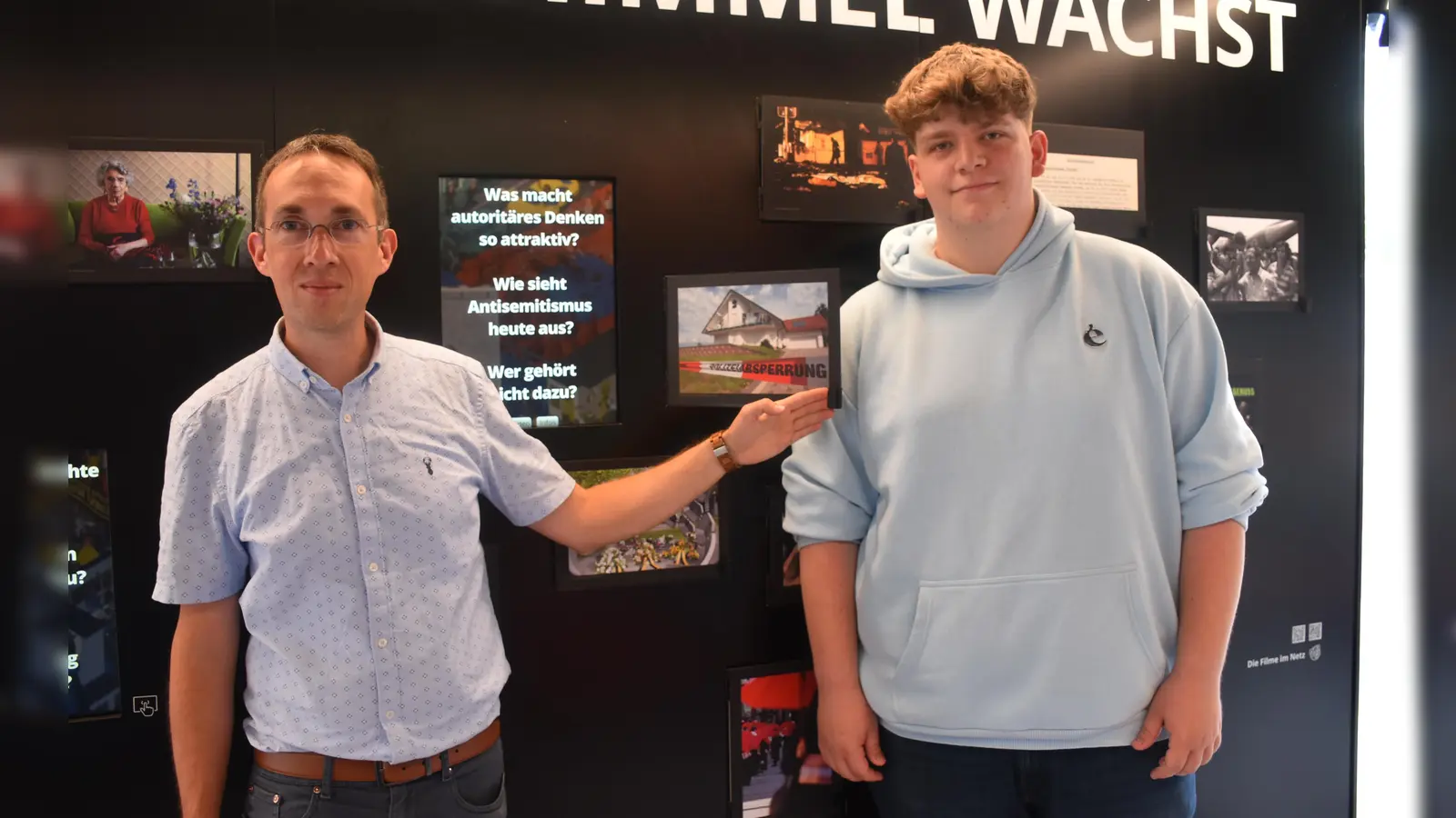 Bürgermeister Marcus Dittrich und Tim Gunkel (Azubi, Bad Karlshafen GmbH) im Innenraum des Containers der Ausstellung „ToleranzRäume“. Hier erinnert auch eine Klappe an die Ermordung des Kasseler Regierungspräsidenten Dr. Walter Lübcke im Jahr 2019.  (Foto: Barbara Siebrecht)