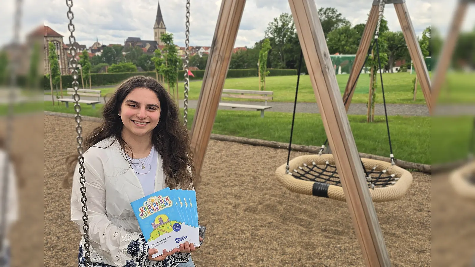 Sila Cakmakci (Auszubildende zur Verwaltungsfachangestellten) präsentiert das Kinderferienprogramm 2026, das allerlei kreative, sportliche und unterhaltsame Aktionen für Kinder und Jugendliche bereit hält. (Foto: Stadt Warburg)