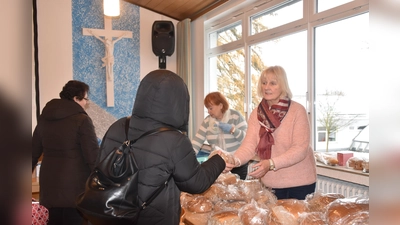 Ingelore Moreau und Gisela Koch reichen Brot und Gebäck an die Gäste weiter. (Foto: Barbara Siebrecht)