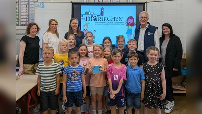 Die Kinder der 1. Klasse der Katholische Grundschule Holzminden gemeinsam mit (v. l.) Isabell Adam von der Stadtmarketing Holzminden GmbH, Stefanie Roland, Schulleiterin Katholische Grundschule Holzminden; Autorin Nina Schiefelbein, Erich Werner, Präsident des Lions Club Holzminden; Michaela Reinecke-Koller, Geschäftsführerin Stadtmarketing Holzminden GmbH. (Foto: Stadtmarketing Holzminden GmbH)