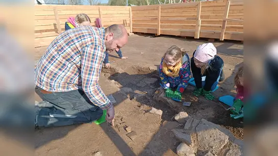 Archäologe Ralf Mahytka legt in Höxter gemeinsam mit großen und kleinen Gartenschau-Gästen einen mittelalterlichen Keller frei.  (Foto: LGS Höxter/Manuela Puls)