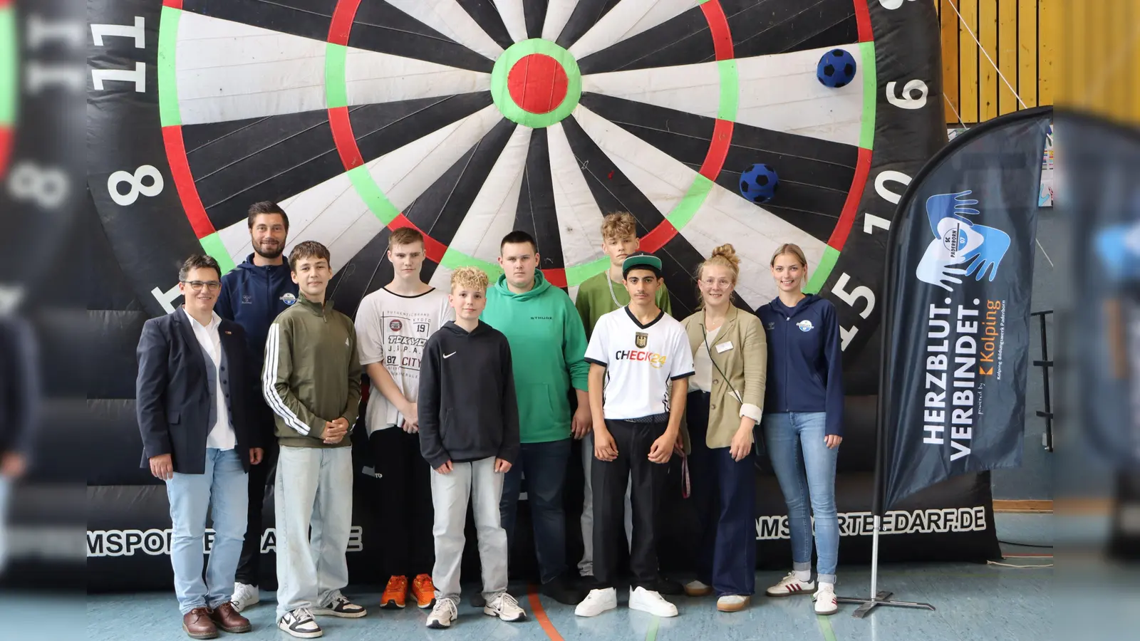 Ein Team vom SC Paderborn 07 hatte bei der Projektwoche und beim Schulfest mit ins Rad gegriffen. (von links: Schulwerk-Geschäftsführerin Eva Klare-Kurtenbach und Christian Strohdiek (SCP07), von rechts Chiara Dreßler (SCP07) und Lehrerin Lena Ortwein mit Schülern aus der Projektgruppe „Fußball“).  (Foto: Jana Sudhoff)