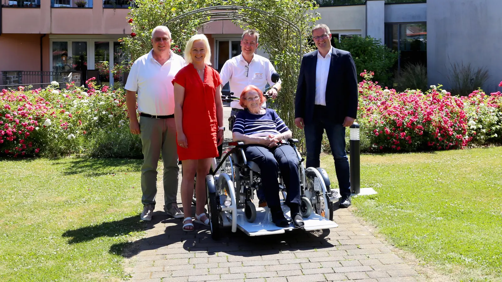 Vertreter der unterstützenden Unternehmen sowie das St. Antonius Seniorenhaus freuen sich über die Inbetriebnahme des neuen Rollstuhfahrrads (von links): Alexander Tölle (Hobatex), Viola Wellsow (Sparkasse Paderborn-Detmold-Höxter), Hildegard Berens (Bewohnerin), Stefan Kruse, Dominik Reineke (Verbund Volksbank OWL); es fehlen Vereinigte Volksbank e.G. und Pax Bank für Kirche und Caritas. (Foto: KHWE)