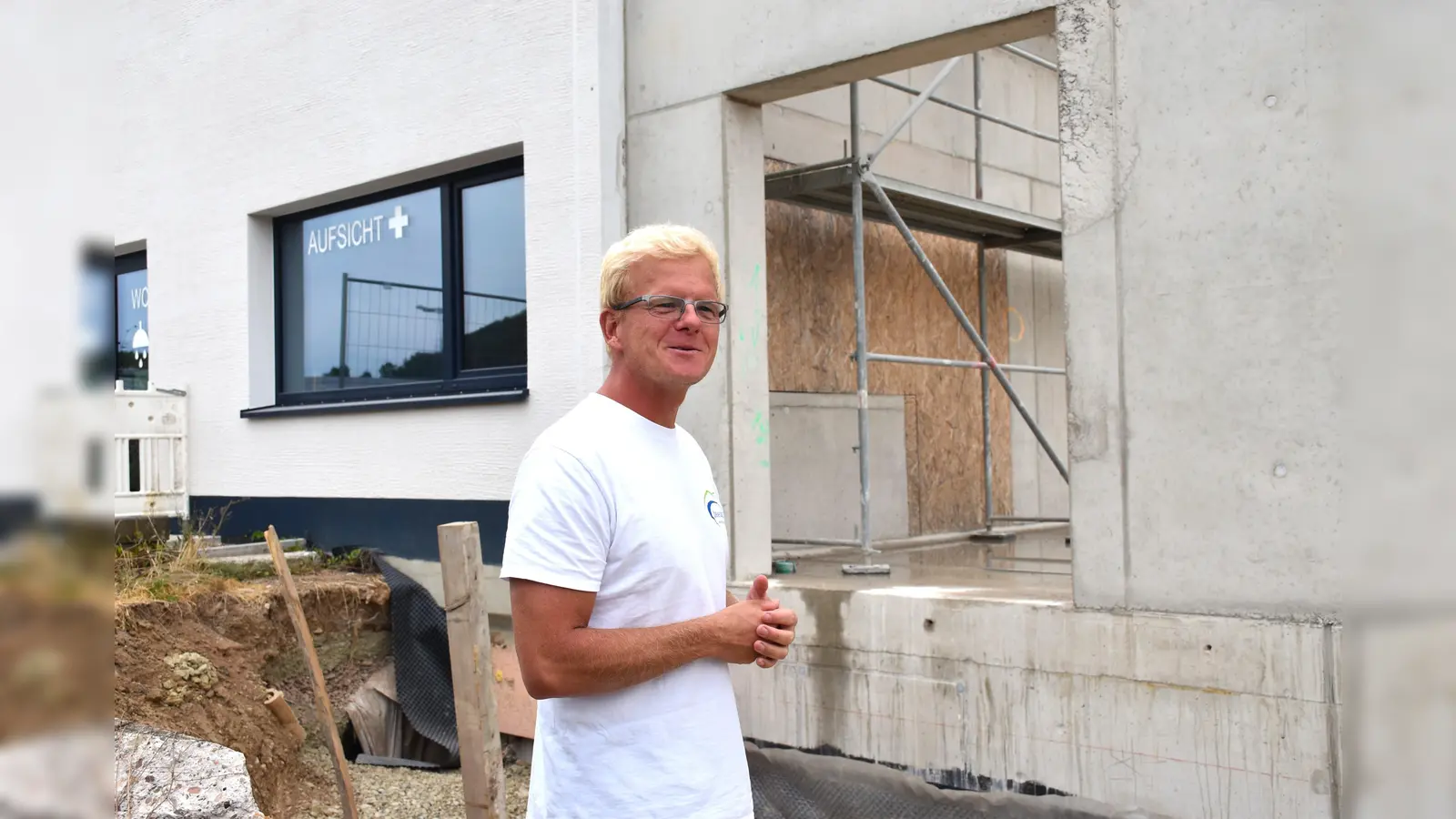 Schwimmmeister Alexander Klaus weist auf den schon vorhandenen Durchbruch zum Hallenbad hin. Der zentralen Aufsichtsraum ist für beide Bäder nutzbar. Die beiden Gebäude sollen auch von der Außenfassade angeglichen werden, so dass sie zu einem Baukörper verschmelzen.  (Foto: Barbara Siebrecht)