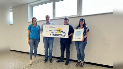 Julia Franzmann (BeSte Stadtwerke), Markus Watermeyer, Yvonne Otto und Beatrix Meyer von der Vereinsgemeinschaft Haarbrück vor den erneuerten Fenstern im Anbau der Bürgerhalle Haarbrück. (Foto: privat)