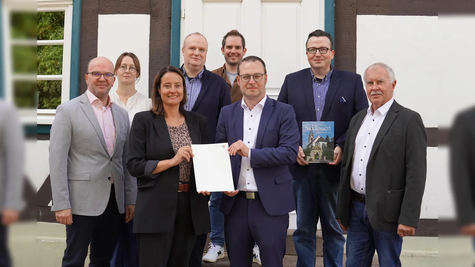 Übergabe des Förderbescheides für die Dachsanierung der Ösehalle in Siddessen: (von links) Andreas Oesselke (Allgemeiner Vertreter des Bürgermeisters), Louisa Lücke-Richter (Fachbereich Planen und Bauen), Regierungspräsidentin Anna Katharina Bölling, Peter Beller (Bezirksverwaltungsstellenleiter), Lucas Luedecke (Fachbereich Planen und Bauen), Bürgermeister Alexander Kleinschmidt, Bezirksausschussvorsitzender Stefan Heilemann sowie Axel Lüdke, Vorsitzender des Hallenbetreibervereins. (Foto: Stadt Brakel)