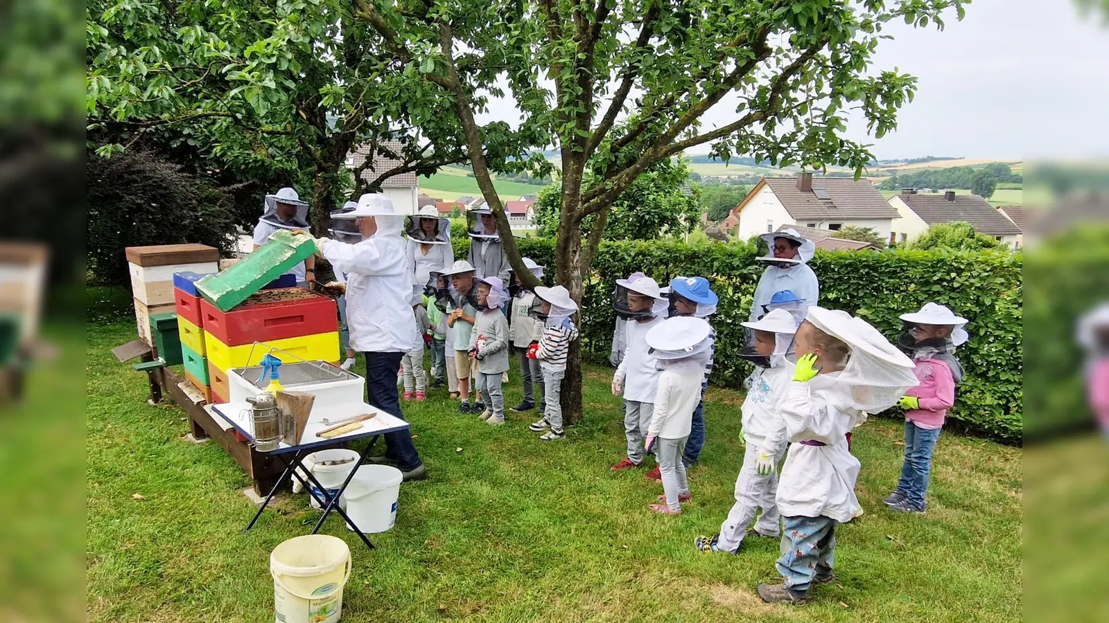 Gut geschützt trauen sich die kleinen Forscher nah an die Bienenvölker. (Foto: Kita Hembsen)