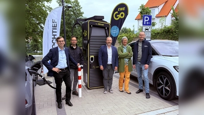 Bürgermeister Tobias Scherf (von links), der Mobilitätsbeauftragte Jan Kolditz, Simon Stein (Geschäftsführer EWE Go HOCHTIEF Ladepartner GmbH &amp; Co. KG), die Mobilitätsausschuss-Vorsitzende Doris Hauck und der Touristiker Lucas Simon zwischen zwei Ladeplätzen, auf denen zukünftig E-Autos mit einer Leistung von bis zu 400 kW pro Ladestation geladen werden können. (Foto: EWE Go)
