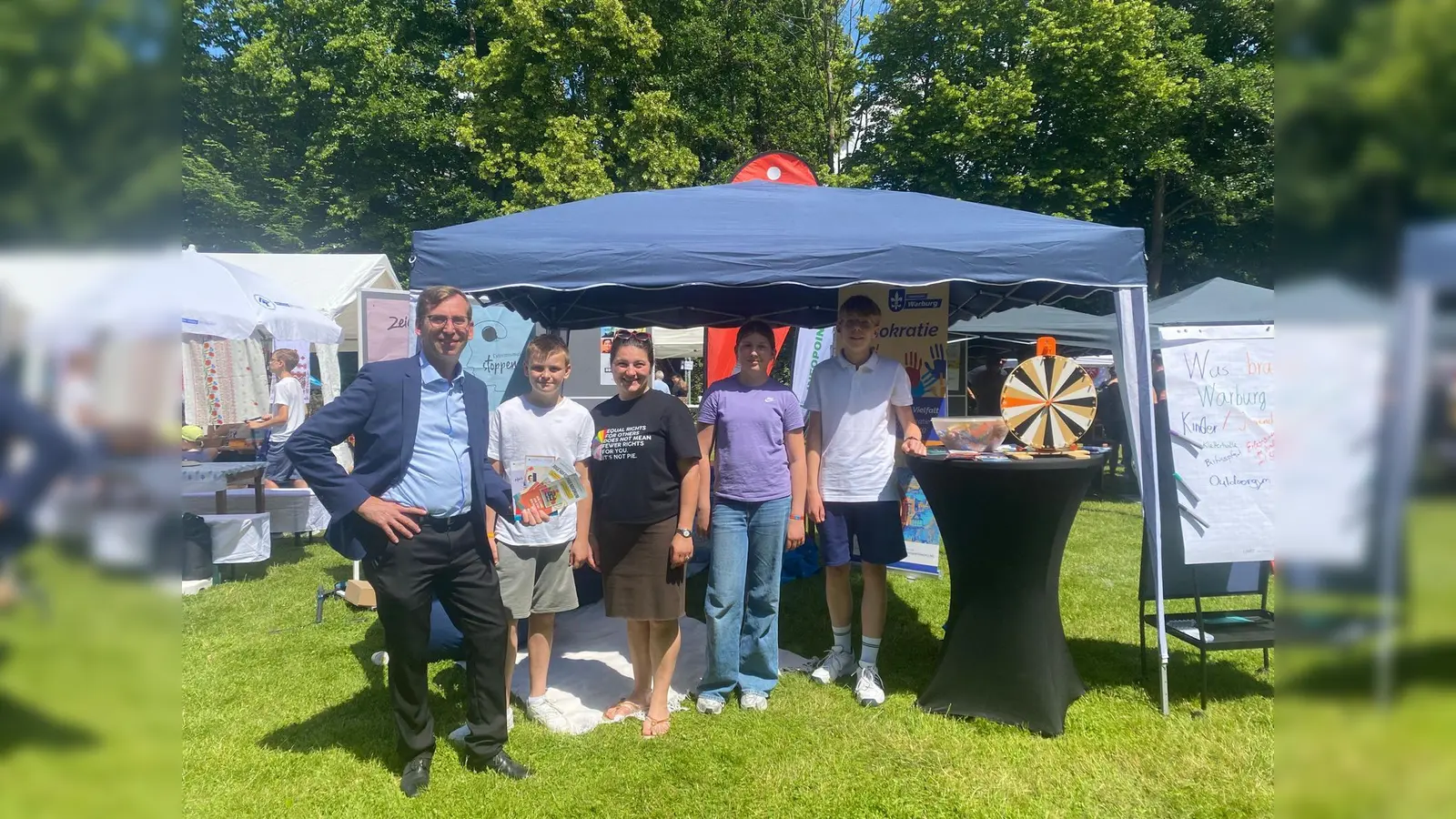 Semira Klenk (3. von links, Koordinations- und Fachstelle des Bundesprogramms „Demokratie leben!“ und Betreuerin des Jugendforums), Bürgermeister Tobias Scherf (1. von links) sowie drei Mitglieder des Jugendforums am Stand von „Demokratie leben!“ auf dem Kreisfamilienfest in Scherfede. (Foto: Stadt Warburg)