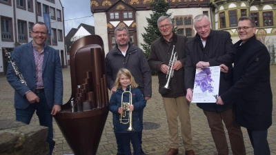(Joachim Quadflieg, Holger Engel mit Tochter Matilda, Reinhard Gerendt vom Sinfonischen Blasorchester, Bürgermeister Daniel Hartmann und Michael Meier von der VerbundVolksbankOWL präsentieren das Programm. (Foto: Stadt Höxter)
