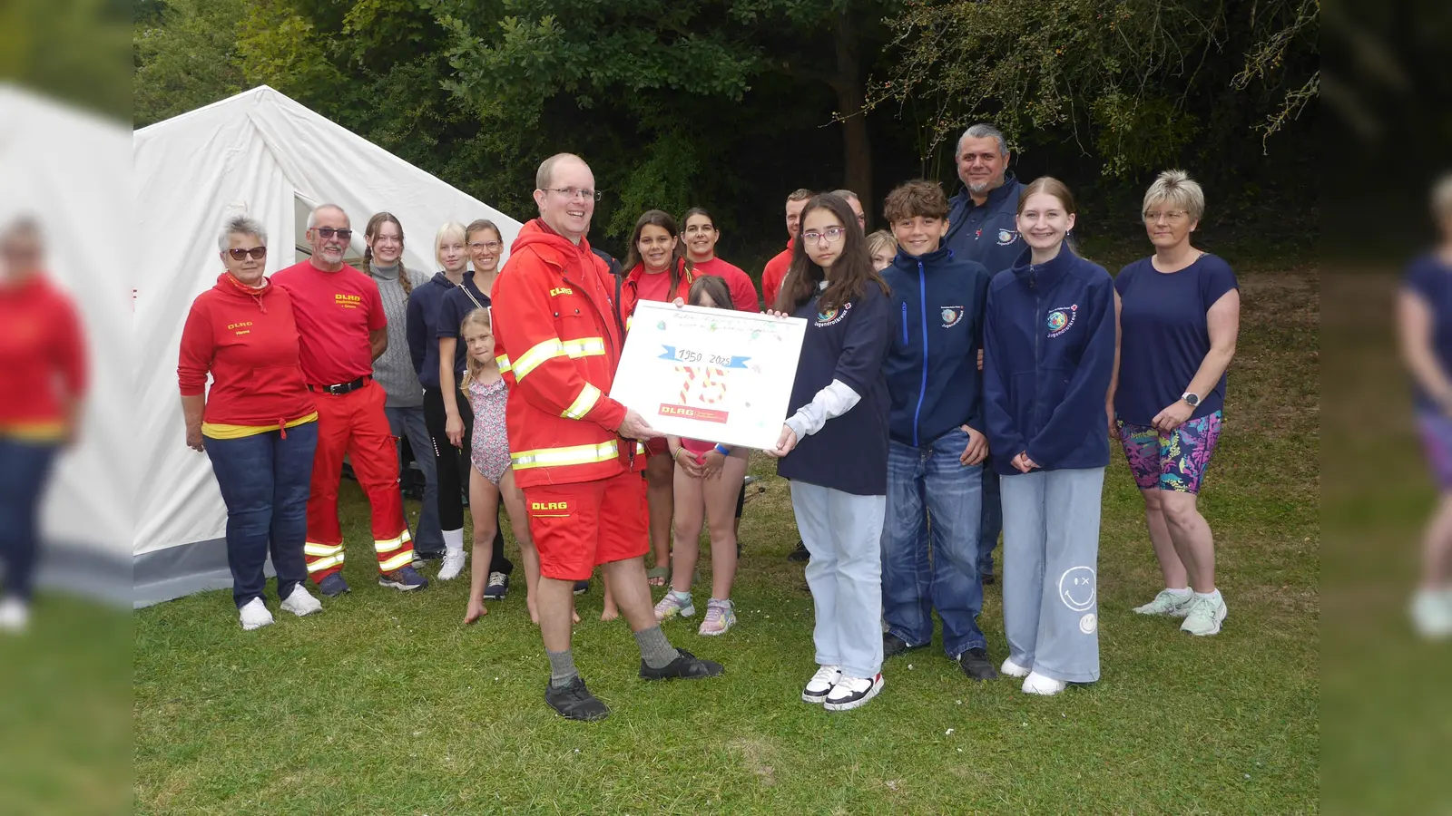 Zum Auftakt der Aqua-Party im Freibad Stadtoldendorf gab es vom Jugendrotkreuz eine selbst gestaltete Urkunde zum 75-jährigen Bestehen, die Paul Koch als Vorsitzender des DLRG-Ortsvereins Stadtoldendorf entgegennahm. (Foto: Kreissportbund Holzminden)