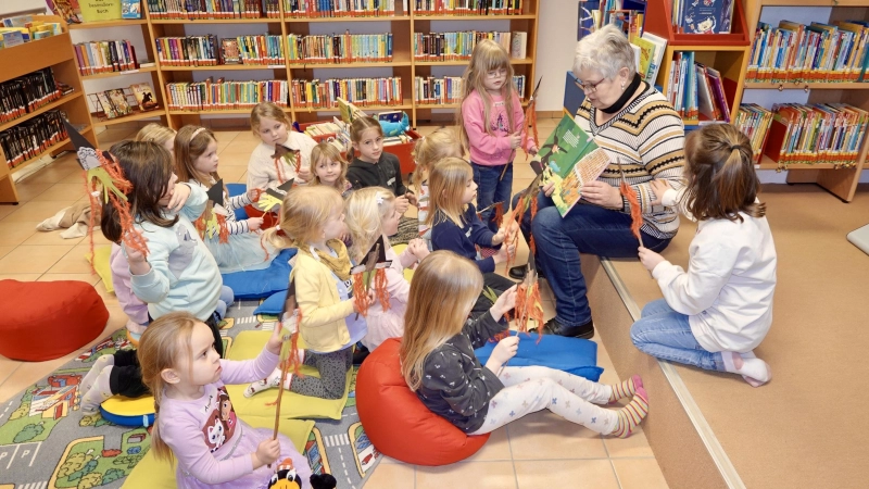 Büchereimitarbeiterin Martina Franke präsentiert den kleinen Büchereigästen „Die Tortenhexe”. (Foto: Die Bücherei Beverungen)