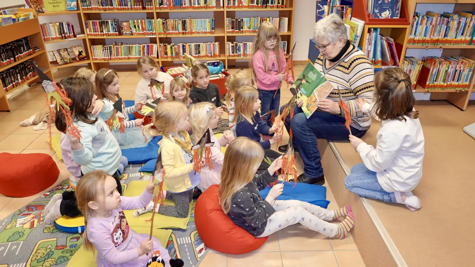 Büchereimitarbeiterin Martina Franke präsentiert den kleinen Büchereigästen „Die Tortenhexe”. (Foto: Die Bücherei Beverungen)