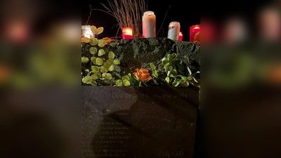 Rosen und Kerzen am jüdischen Friedhof am Emil-Herz-Platz. Ein Eindruck von der Gedenkveranstaltung 2025  (Foto: Valeria Geritzen)