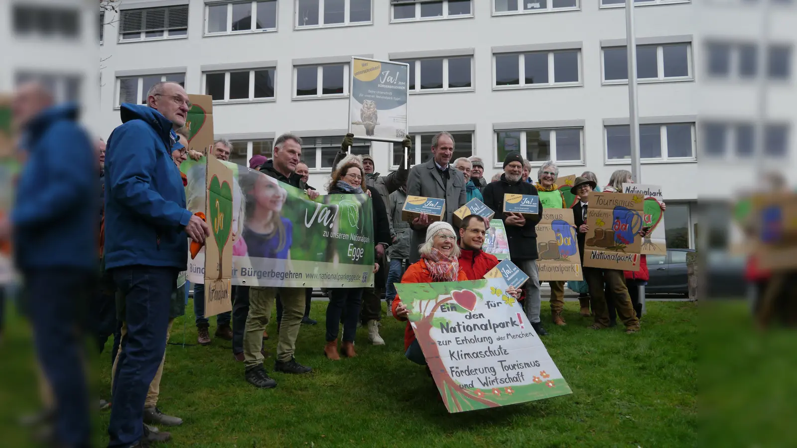 Aktive und Unterstützer des Bündnisses für das Bürgerbegehren vor der Kreisverwaltung. Die vier Kartons mit den Unterschriften halten die drei Vertretungsberechtigten für das Bürgerbegehren (Bildvordergrund, Mitte) Dr. Ulrich Kros und Dr. Burkhard Beinlich (stehend) sowie Benedikt Rasche (kniend). (Foto: Ludger Roters)