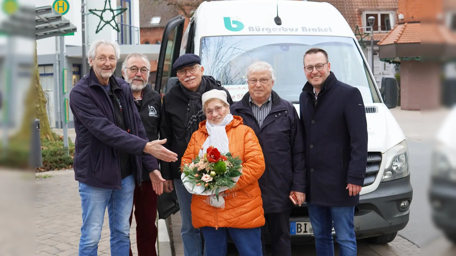 Frieda Wauer (Mitte) war der 12.000 Fahrgast im Bürgerbus in diesem Jahr. Es gratulierten (von links) Rainer Pauli, Werner Hoormann, Erwin Zimmermann, Rainer Krelaus und Bürgermeister Alexander Kleinschmidt. (Foto: Stadt Brakel)