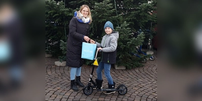 Flora-Marie Staff (Beverungen Marketing) mit dem Gewinner des Hauptpreises im KInderweihnachtsspiel Jim Siemens (9 Jahre) und dem Hauptpreis, einem Tretroller.  (Foto: Barbara Siebrecht)