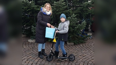 Flora-Marie Staff (Beverungen Marketing) mit dem Gewinner des Hauptpreises im KInderweihnachtsspiel Jim Siemens (9 Jahre) und dem Hauptpreis, einem Tretroller.  (Foto: Barbara Siebrecht)