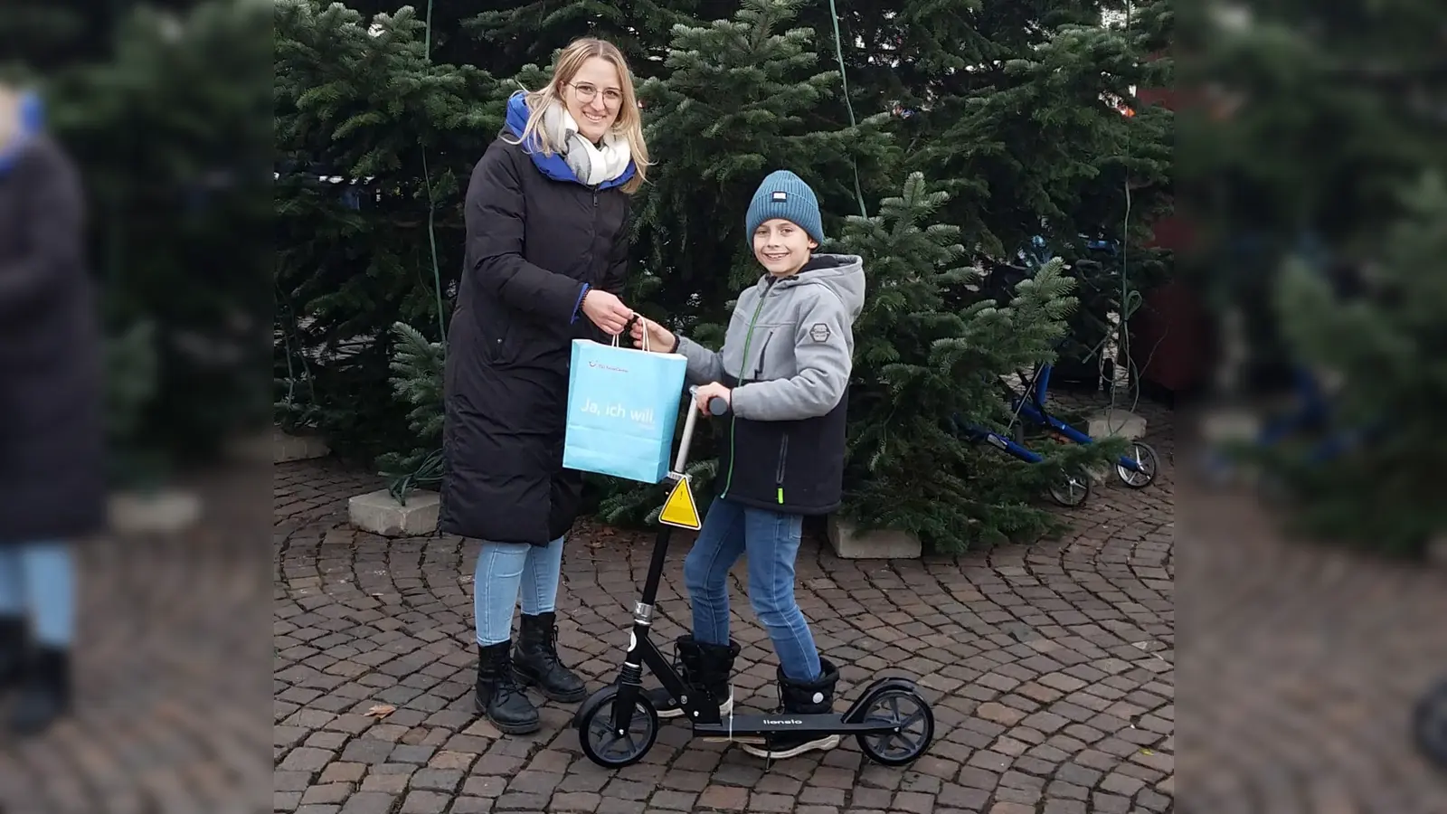 Flora-Marie Staff (Beverungen Marketing) mit dem Gewinner des Hauptpreises im KInderweihnachtsspiel Jim Siemens (9 Jahre) und dem Hauptpreis, einem Tretroller.  (Foto: Barbara Siebrecht)