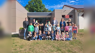 Die Kinder der Klasse 2a der Katholischen Grundschule Borgentreich freuen sich mit (v.l.) Hendrik Temme (Fachbereichsleiter Stadt Borgentreich), Hendrik Rottländer (Klimaschutzmanager Stadt Borgentreich), Borgentreichs Bürgermeister Nicolas Aisch (Bürgermeister Borgentreich), Stephanie Sievers (Klassenlehrerin 2a) und Regina Thesing (Rektorin) über die Möhrchenhefte. (Foto: Kreis Höxter)