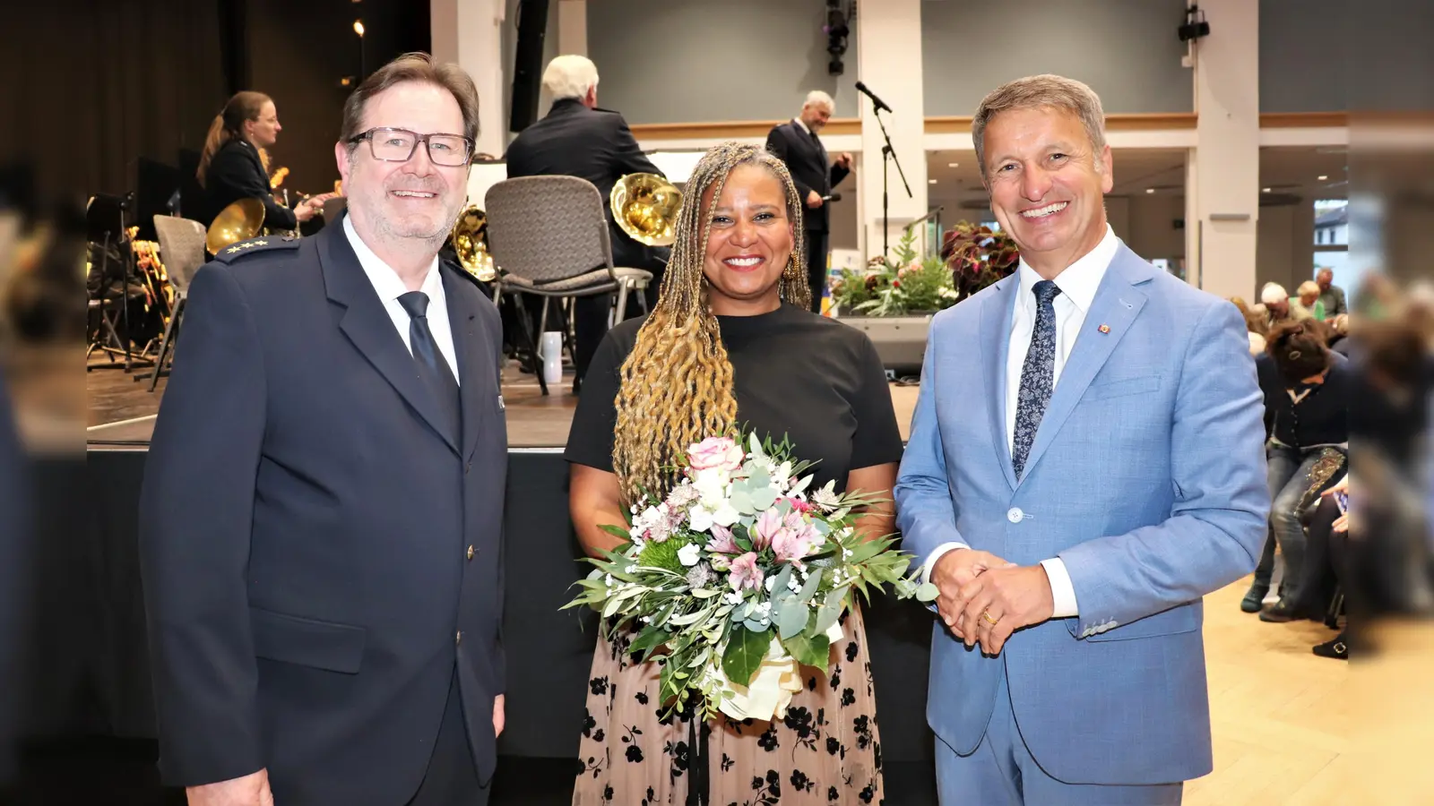 Blumen für die Solistin. Polizeidirektor Christian Brenski (links) und Landrat Michael Stickeln (rechts) danken Polizeioberrätin Patricia Nubi. (Foto: Kreispolizeibehörde Höxter)