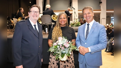 Blumen für die Solistin. Polizeidirektor Christian Brenski (links) und Landrat Michael Stickeln (rechts) danken Polizeioberrätin Patricia Nubi. (Foto: Kreispolizeibehörde Höxter)
