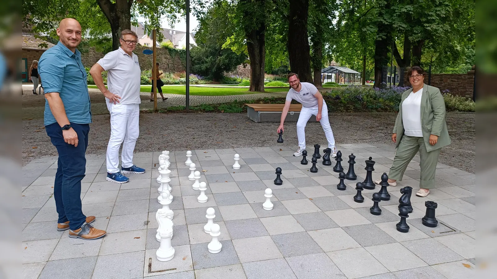 Auf eine Partie: LGS-Geschäftsführer Jan Sommer (v.l.), die Apotheker Elmar Wiederhake und Hauke Bitterberg sowie Claudia Sommer (LGS-Geschäftsführung) beim Schachspiel am Berliner Platz.  (Foto: LGS Höxter/Manuela Puls)