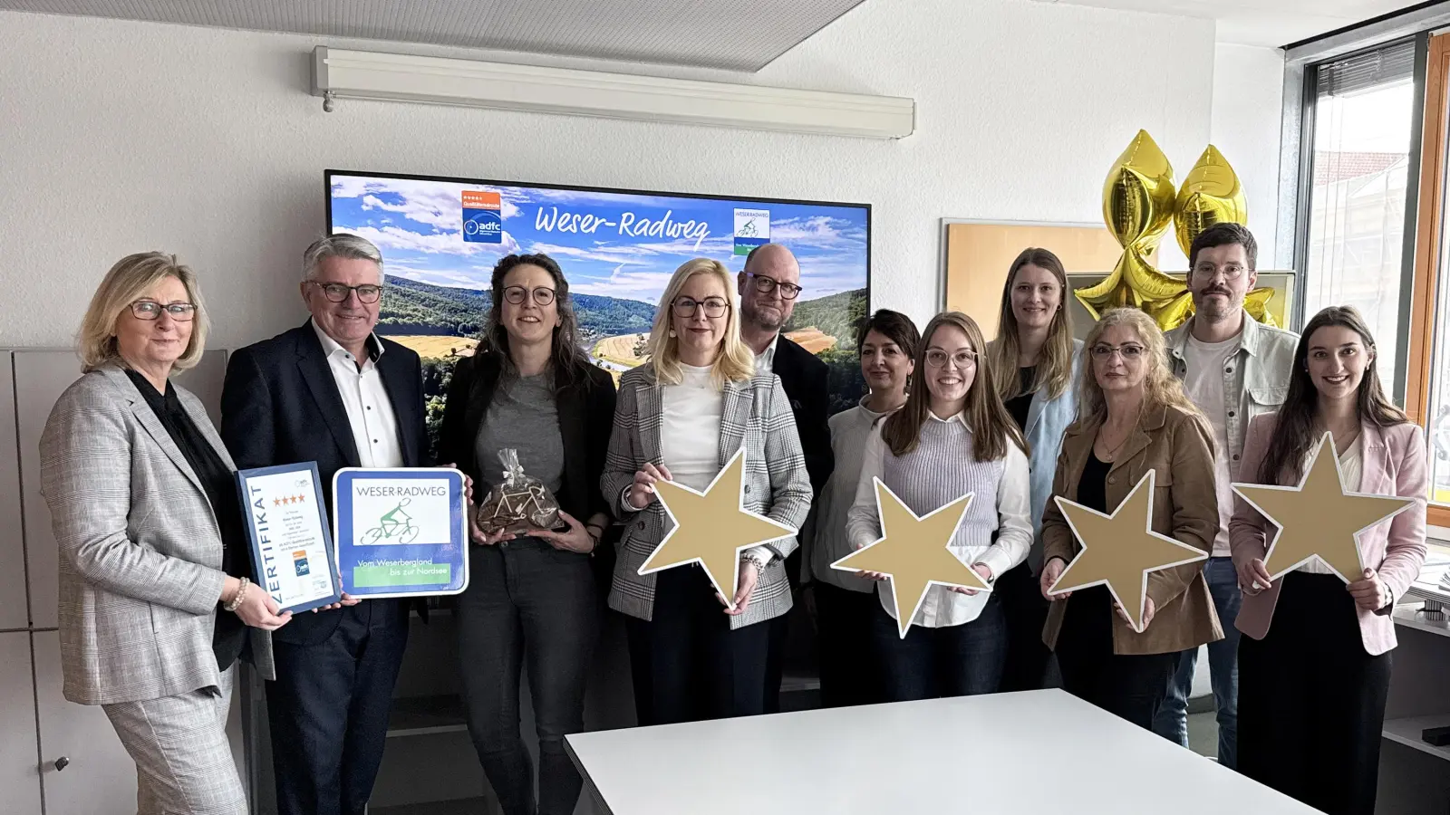 Die Weser-Radweg Kooperationspartner sowie der Landkreis Hameln-Pyrmont als Koordinierungsstelle aller Landkreise im Rahmen der Zertifizierung freuen sich über die 4-Sterne-Zertifzierung (v.l.): Petra Wegener (Weserbergland Tourismus e.V.), Dr. Joachim Steinbeck (Landkreis Hameln-Pyrmont), Sina Scholz (Weserbergland Tourismus e.V.), Sonja Kuhn und Martin Fahrland (Mittelweser-Touristik GmbH), Anke Fiedler (Touristikgemeinschaft Teufelsmoor), Franziska Bein (Touristikgemeinschaft Wesermarsch), Marie von Borstel (Cuxland-Tourismus), Tülay Sukes (Erlebnis Bremerhaven), Marco Skora, WFB Wirtschaftsförderung Bremen GmbH), Selina Rösemeier (Landkreis Hameln-Pyrmont). (Foto: Weserbergland Tourismus e.V.)