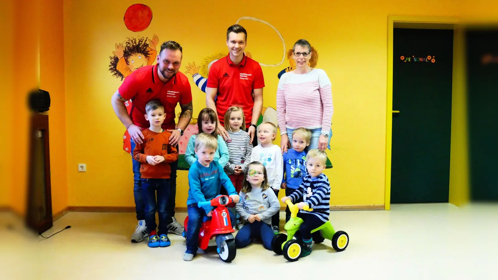 Hinten v.l.: Alexander Stoyhe und Henning Hampe vom Förderverein sowie Erzieherin Christina Sonne freuen sich mit den Kindergartenkindern über die Outdoor-Fahrzeuge. (Foto: Foto: privat)