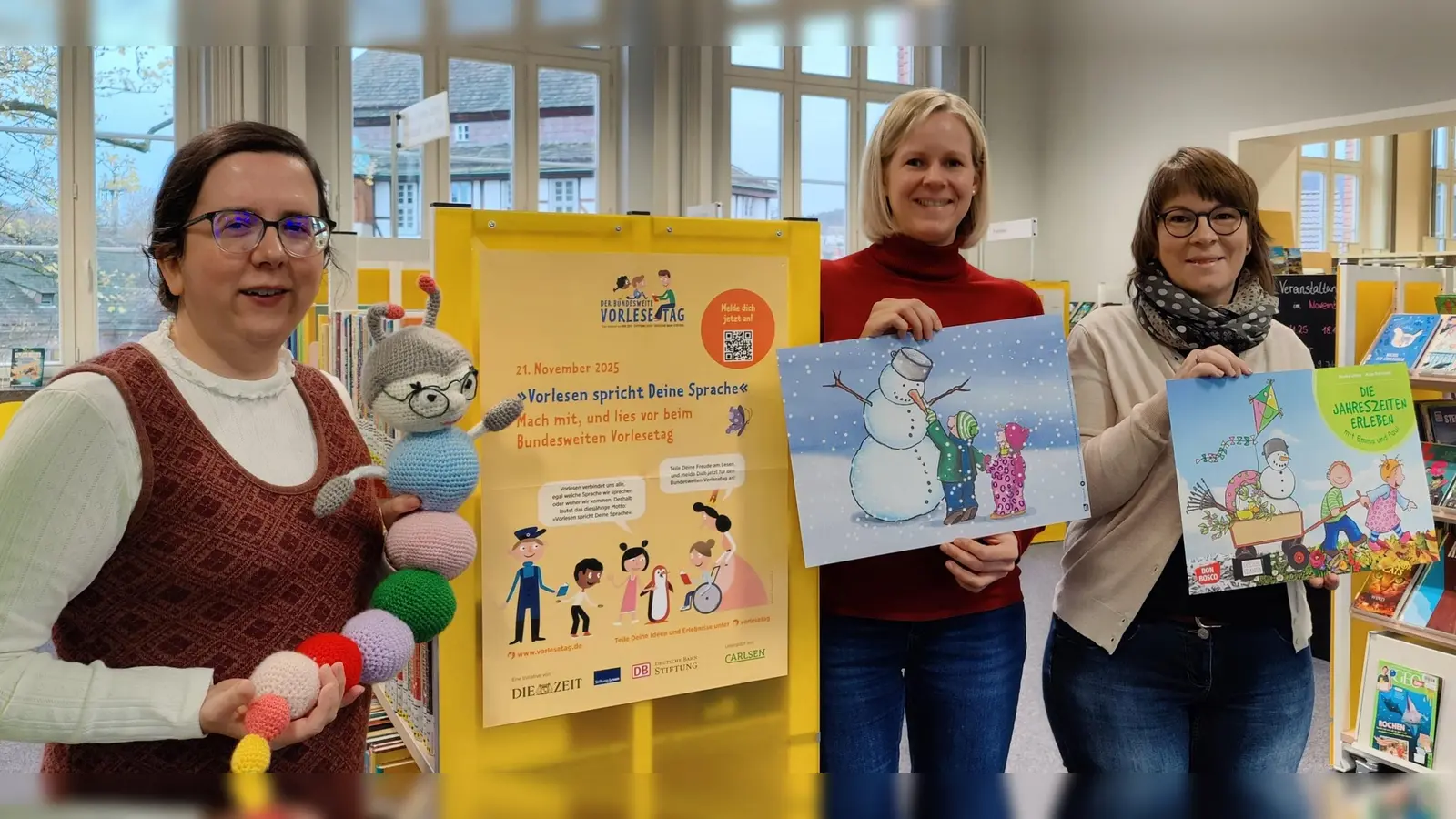 Büchereileiterin Christiane Bode, die Mitarbeiterinnen Nina Theresa Sander und Nicole Raabe sowie Maskottchen Lilo laden zur literarischen Krabbelgruppe am Bundesweiten Vorlesetag in die Stadtbücherei Höxter ein. (Foto: Stadt Höxter)