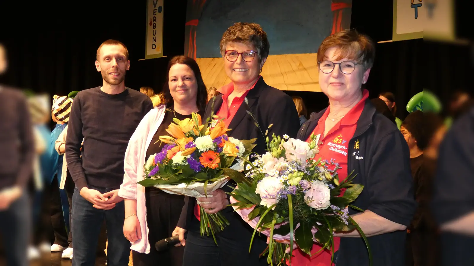 Schulleiterin Birgit Riepe-Dewender und der Konrektorin Dagmar Schmidt erhielten einem Blumenstrauß für die Organisation des Jubiläumsfestes von den Elternvertretern Natalie Dulaj und Julian Wiemers. (Foto:  Grundschulverbund)