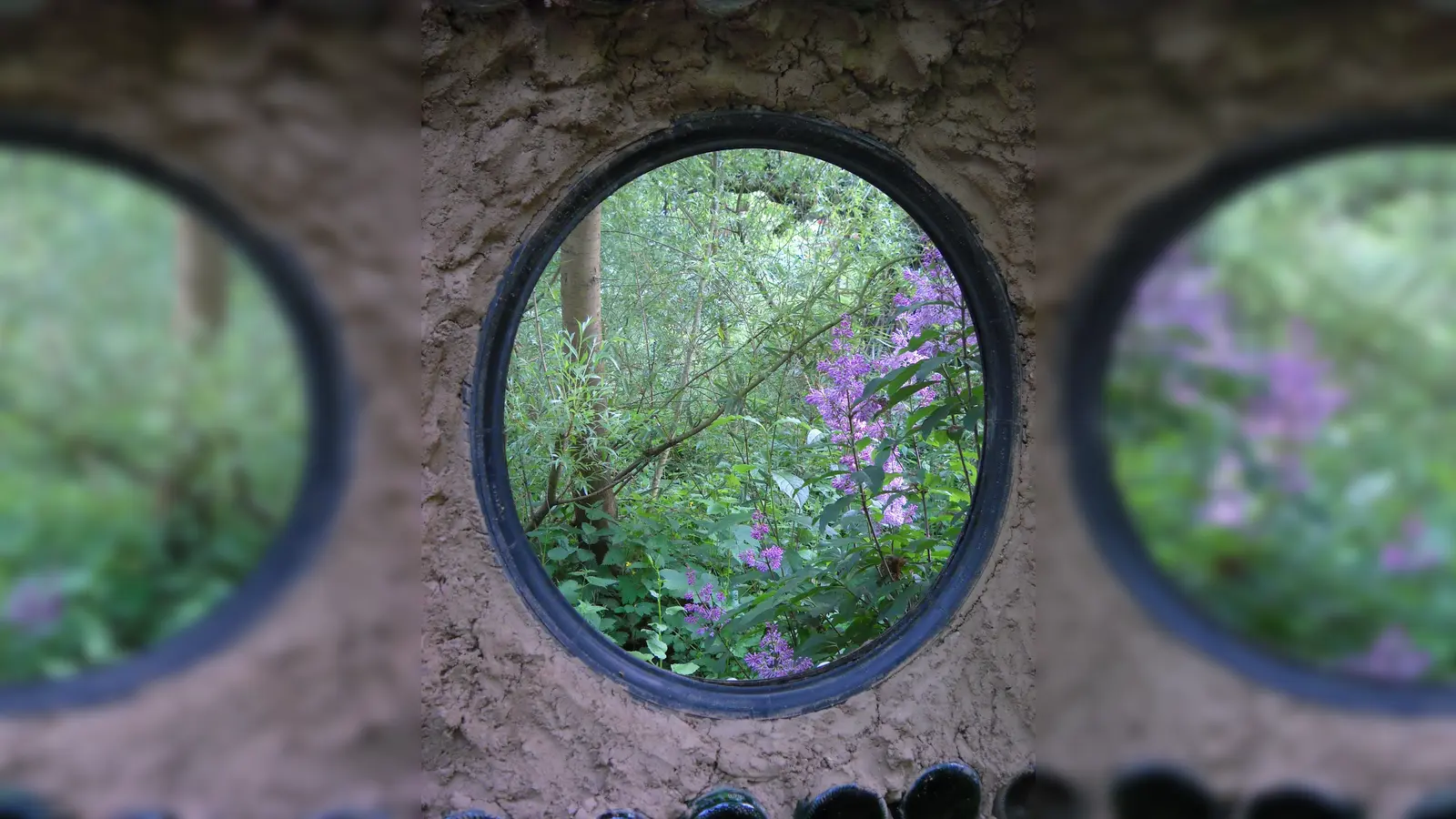 Flaschenwand mit Flieder im Höxteraner Paradiesgarten. (Foto: privat)