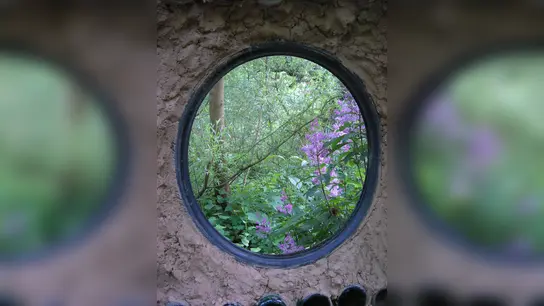 Flaschenwand mit Flieder im Höxteraner Paradiesgarten. (Foto: privat)