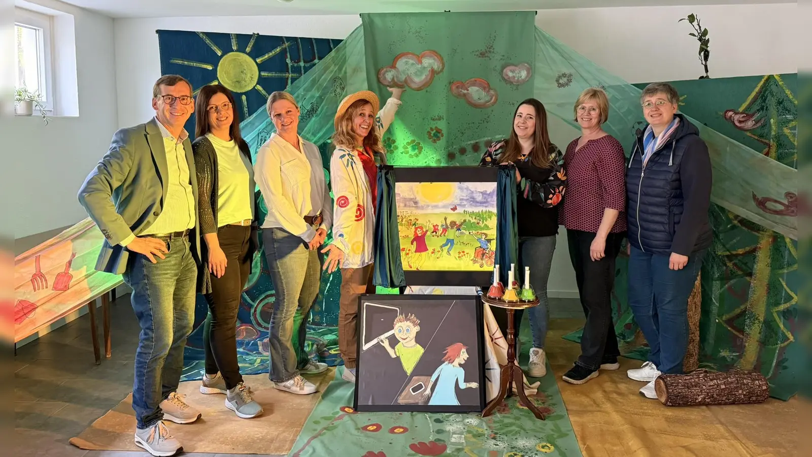 Das Kindertheater Radelrutsch macht Lust auf die Welt hinter dem Bildschirm (v.l.): Bürgermeister Tobias Scherf, Sonja Ehle (Pädagogische Fachkraft und stellvertretende Einrichtungsleitung), Silke Drese (Pädagogische Fachkraft und Einrichtungsleitung), Yasmin Röckel (Kindertheater Radelrutsch), Carolin Kitta (Pädagogische Fachkraft), Birgit Redeker (Bücherei-Team Daseburg) und Susanne Stoppelkamp (Pädagogische Fachkraft). (Foto: Stadt Warburg)