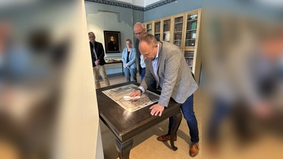 Landrat Michael Schünemann auf Detailsuche auf den Seiten der Wenzelsbibel. (Foto: Landkreis Holzminden)