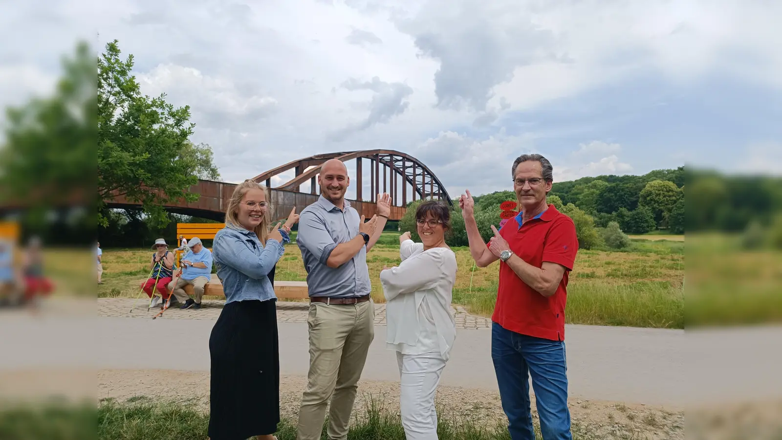 Anna-Lena Ruberg (LGS Veranstaltungen, v.l.), Jan Sommer (Geschäftsführer), Claudia Koch (Geschäftsführerin) und Uwe Acker (LightArt Show Production aus Detmold) bringen Höxters Gartenschau im Oktober zum Leuchten – auch die rostige Eisenbahnbrücke im Hintergrund.  (Foto: LGS Höxter/Manuela Puls)