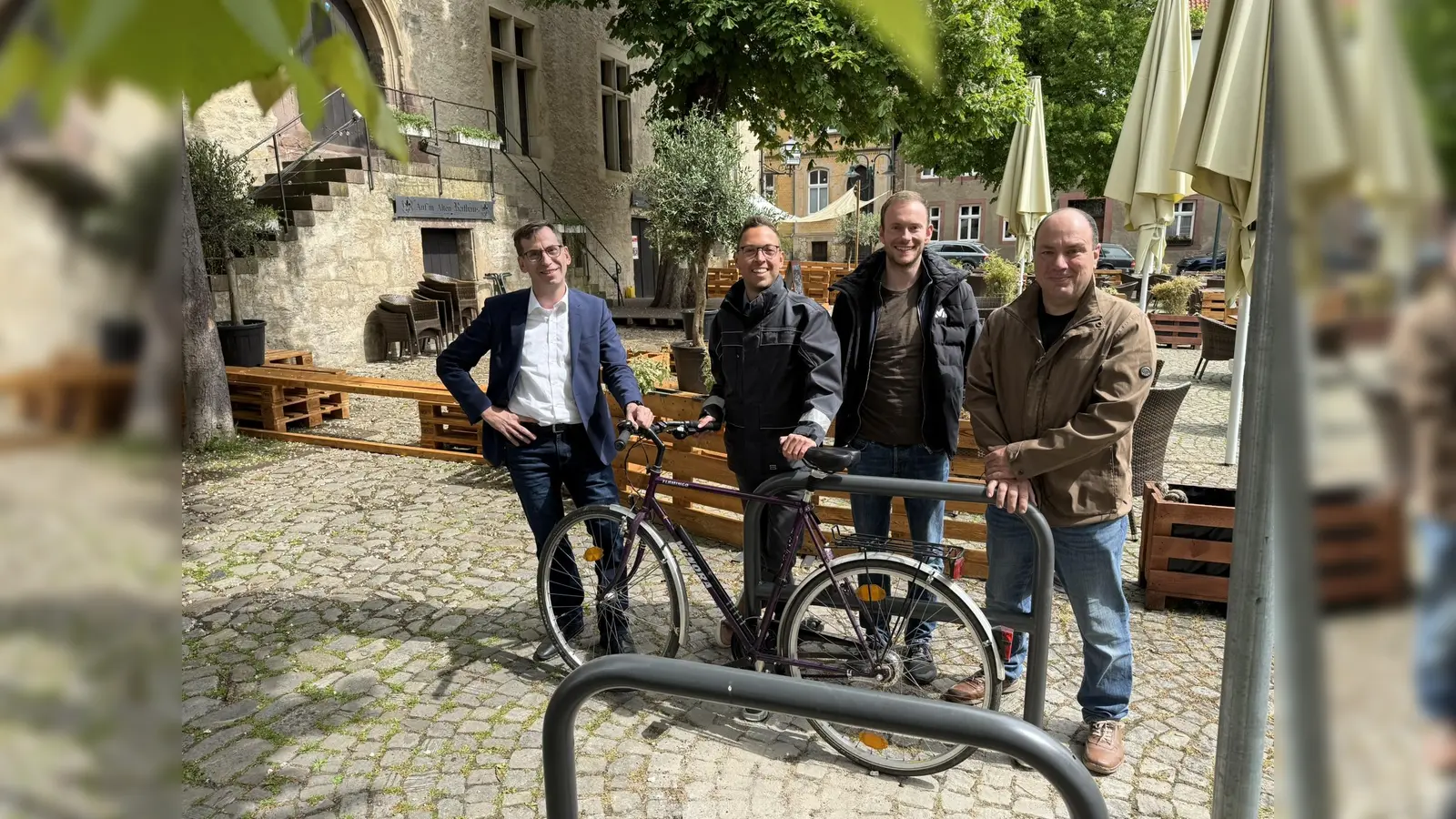 Markus Bischof von der Holzschindelmanufaktur Bischof (rechts) hat die acht neuen Fahrradparker installiert. Bürgermeister Tobias Scherf (von links), der Mobilitätsbeauftragte Jan Kolditz und Touristiker Lucas Lambracht freuen sich über die Ergebnisse. (Foto: Stadt Warburg)
