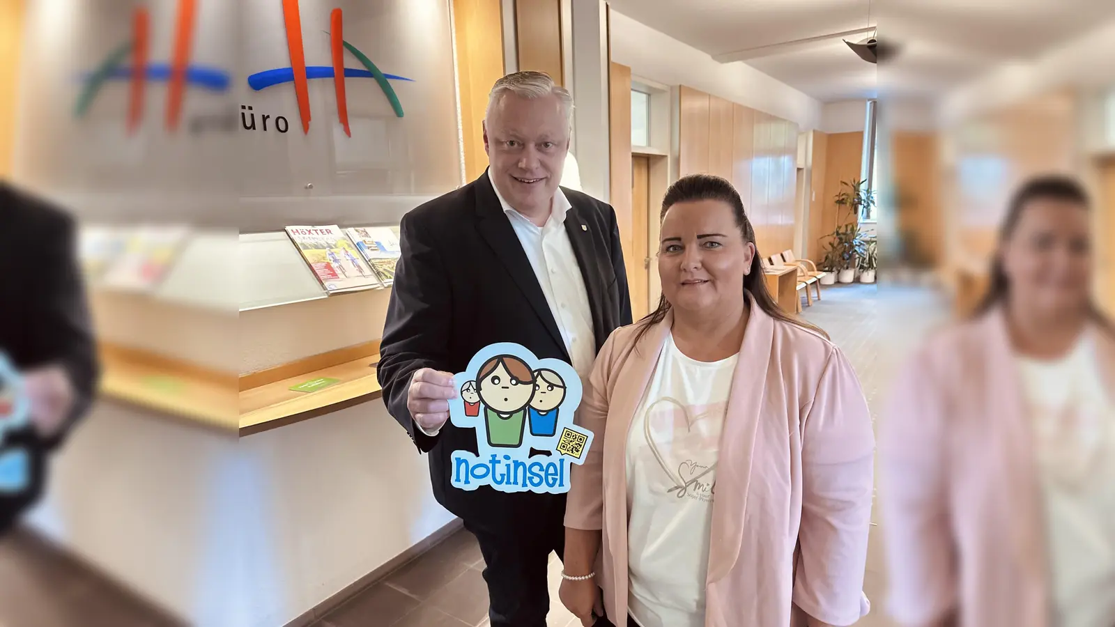 Bürgermeister Daniel Hartmann und Nadine Nolte von der Stabstelle Familie der Stadt Höxter präsentieren im Bürgerbüro Höxter das Notinselschild. Ein sichtbares Zeichen für mehr Sicherheit und Hilfe für Kinder im Alltag. (Foto: Stadt Höxter)