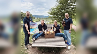 Christoph Missing (Kassenwart), Markus Finger (stellvertretender Vorsitzender,v.l.), Claudia Pelz-Weskamp(Vorsitzende), und Stefan Borgolte (Schriftführer) mit Dackel Lothar freuen sich auf viele Picknickbesucher auf der Weserscholle. (Foto: Bürgerstiftung Höxter)