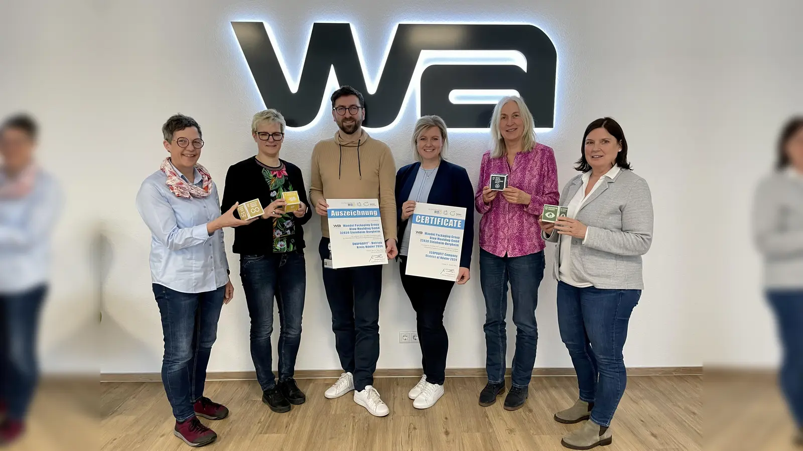 Kosten senken und gleichzeitig die Umwelt schonen – So lautet das Ziel des Projektes ÖKOPROFIT, das zum dritten Mal im Kreis Höxter durchgeführt wird. Drei Unternehmen – wie etwa die Wandel Packaging Group Blow Moulding aus Steinheim-Bergheim – konnten bereits rezertifiziert werden. Darüber freuen sich Martina Krog (Klimaschutzbeauftragte des Kreises Höxter), Dr. Kathrin Weiß (Leiterin des Fachbereichs Umwelt, Bauen und Geoinformationen des Kreises Höxter), Roman Preis, Anja Breker (beide Wandel Packaging), Dorothee Meier (B.A.U.M. consult) und Dr. Claudia Auinger (IHK Ostwestfalen-Lippe). (Foto: Kreis Höxter)