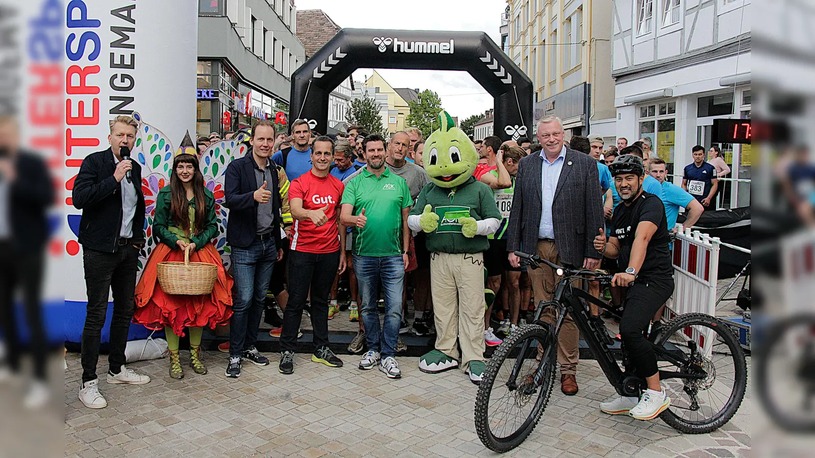 Startbild aus den Vorjahren (v.l.): Moderator Markus Finger; Maskottchen Holli (LGS); Jens Klingemann (Geschäftsführer Sport- und Modehaus Klingemann), Jörg Albers (Sparkasse in Höxter), Matthias Wehmhöner (AOK-Serviceregionsleiter), AOK-Maskottchen ‚Jolinchen‘; Bürgermeister Daniel Hartmann, Karsten Gonzaga (Intersport Klingemann). (Foto: AOK/hfr.)