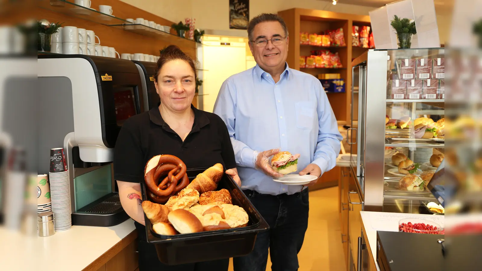 Die Cafeterien der Krankenhäuser in Brakel und Bad Driburg werden ab sofort von der KWE Service betrieben. Servicekraft Sylvia De Meyer (links) und Servicemanager Hans-Michael Koziollek präsentieren einen Teil des neuen Angebots. (Foto: KHWE)