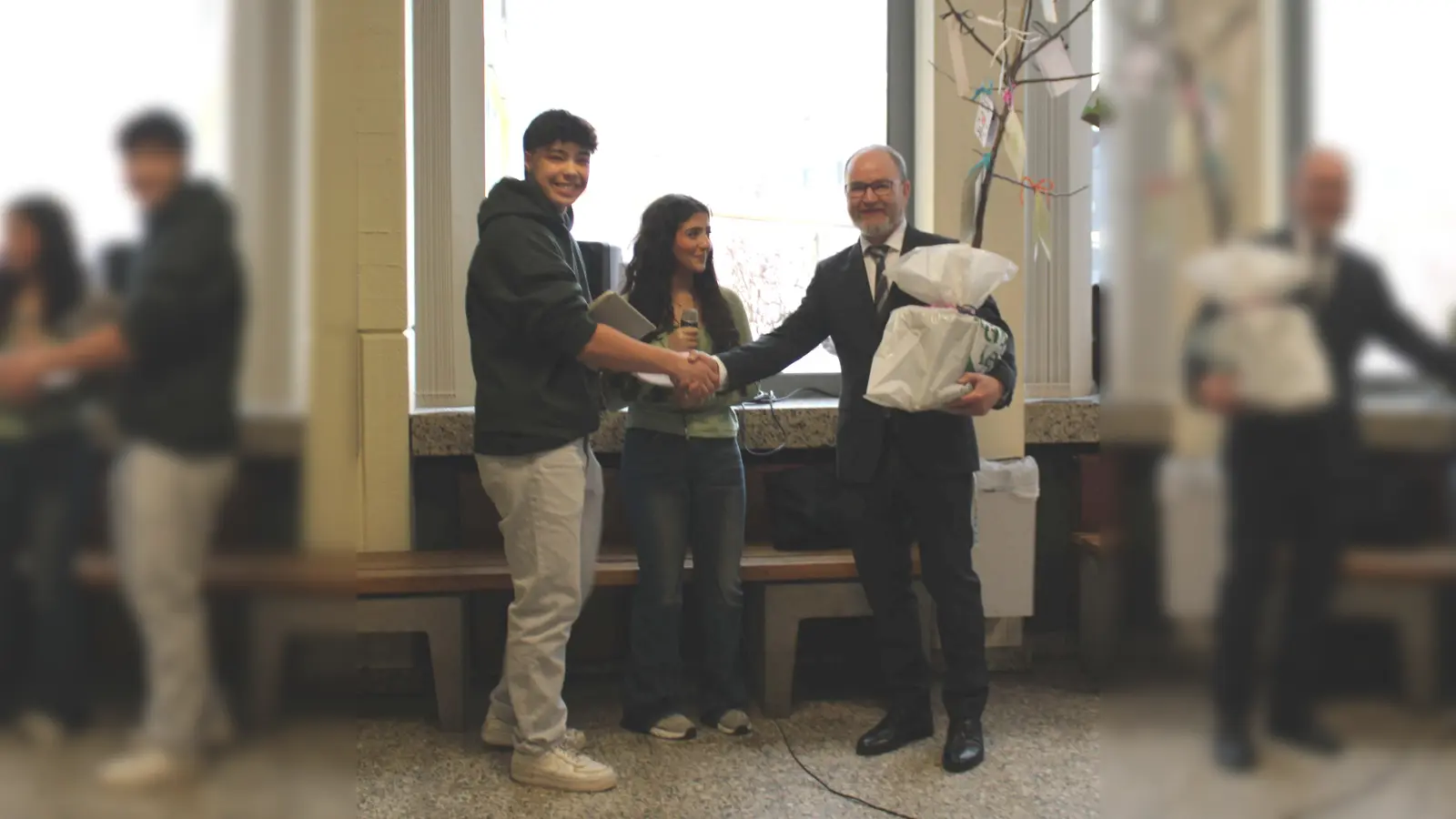 Max Kremeier und Maiss Rhuma vom Schülersprecherteam am SGS überreichen Marko Harazim einen Apfelbaum als Abschiedsgeschenk der Schüler. (Foto: Michael Volmer, Städtisches Gymnasium Steinheim)