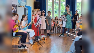 Mit Begeisterung auf der Bühne: Der JeKits-Chor und die Ukulelen-Gruppe der Schule am Nicolaitor erzählen musikalisch die Geschichte von rasenden Affen. (Foto: Stadt Höxter)