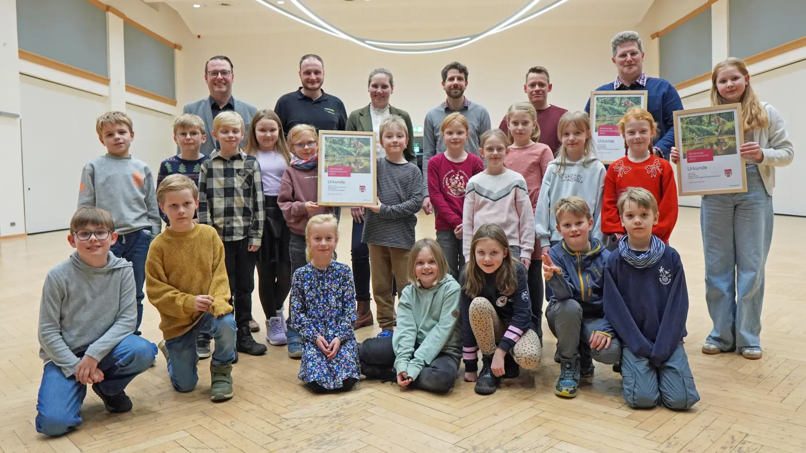 Die Klimaschutz-Sieger 2025 wurden am 8. Dezember durch Bürgermeister Alexander Kleinschmidt (hinten von links), Sven Müller (Westnetz) und Maria Kemker (Westenergie) ausgezeichnet. (Foto: Stadt Brakel)