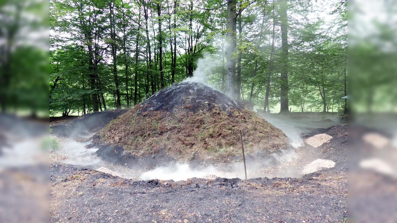 Einmal jährlich wird die alte Handwerkskunst der Köhlerei in Uslar-Delliehausen präsentiert. Das Anstecken des Holzkohlenmeilers wird mit einem Meilerfest am ersten Sonntag im Juni gefeiert. (Foto: Touristik-Information Uslar, W. Laufer)