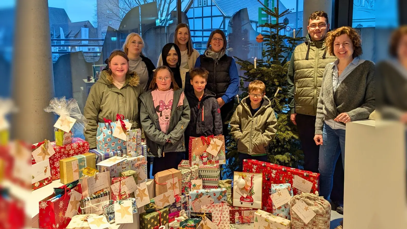 Isabell Adam (rechts) hat 45 von Holzmindenern gepackte Weihnachtsgeschenke an Melanie Hübner (hinten Mitte) und Sonja Rosenwinkel (links daneben) von der Stiftung Kinderheimat Neuhaus überreicht. (Foto: Stadtmarketing Holzminden GmbH)