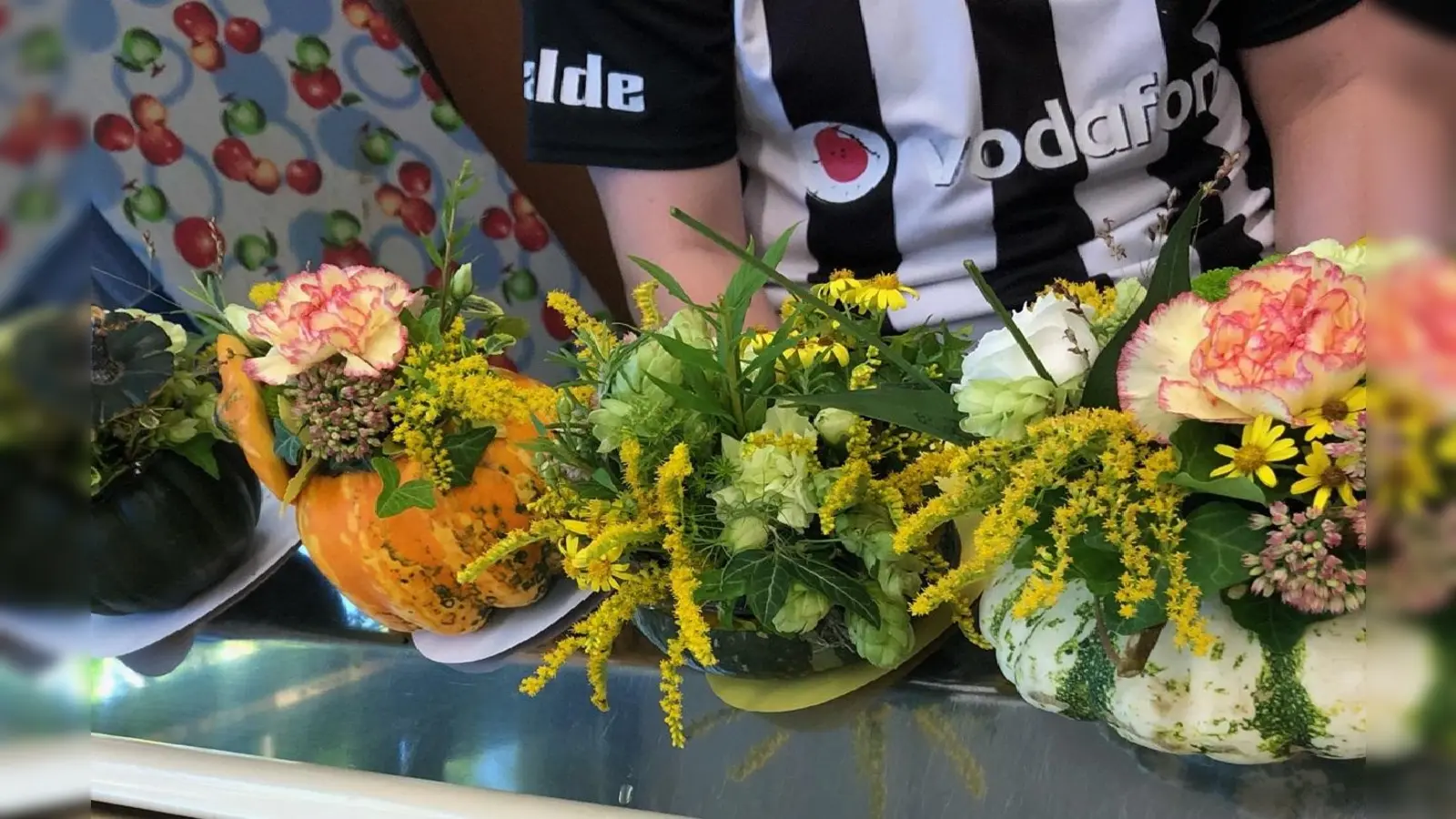 Schüler des Berufskollegs Kreis Höxter in Brakel füllen Kürbisse für die nächste Blumenhallenschau mit herbstlichen Blüten. (Foto: Berufskolleg Kreis Höxter/Hildegard Nutt)
