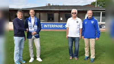 Der Vorsitzende des Fußballvereins Blau-Weiß-Weser, Gerd Henke (v. l) und Kevin Eschenlohr, Prokurist der AGC Interpane Holding GmbH besiegeln das Sponsoring mit einem Handschlag. Über die Unterstützung freuen sich auch Zedin Piljug (Finanzen) und Ralf Schreck (Facility Manager und Schriftführer).  (Foto: Barbara Siebrecht)